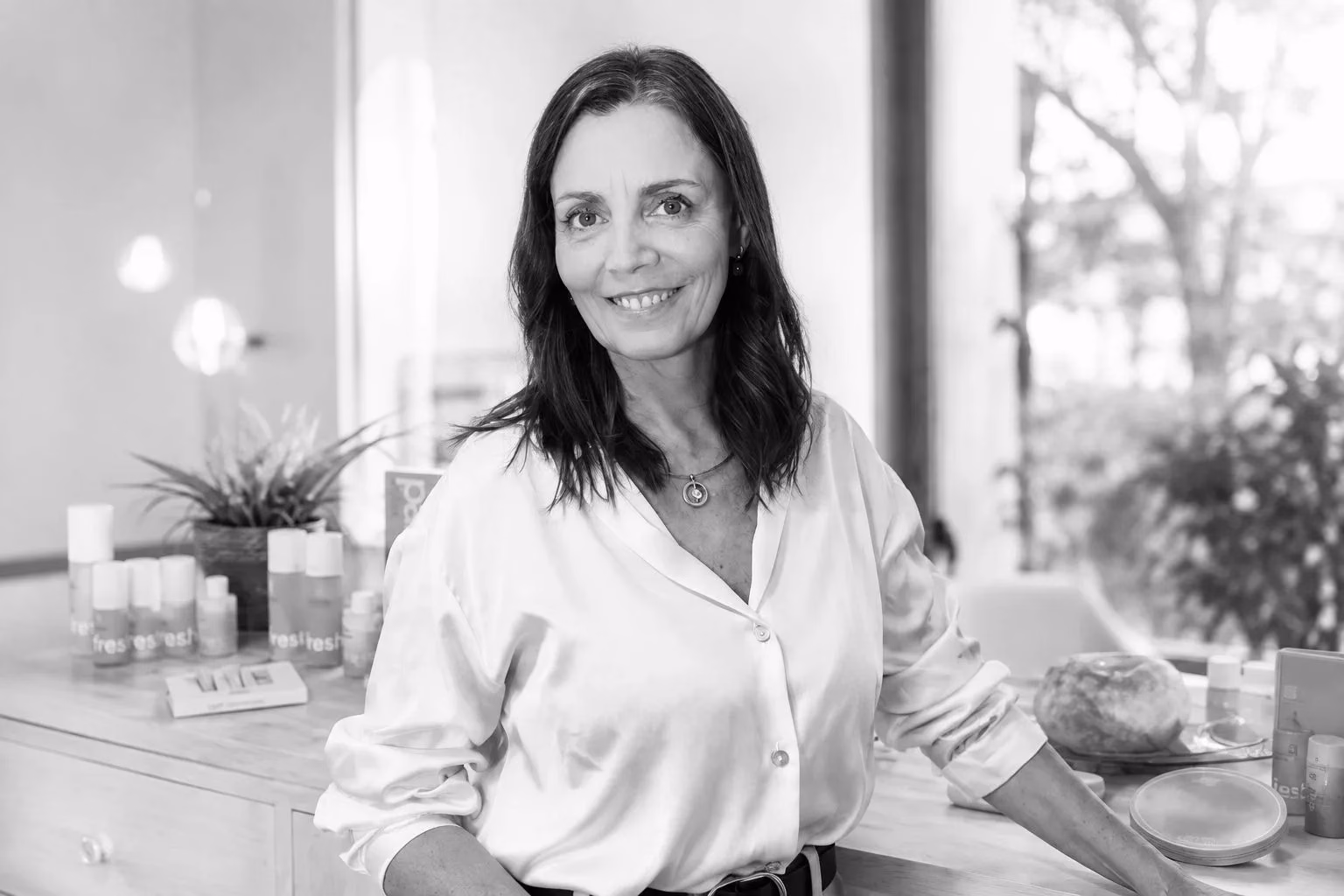 Anna Maria Bordes apoyada en el mostrador de su espacio de trabajo, en blanco y negro.
