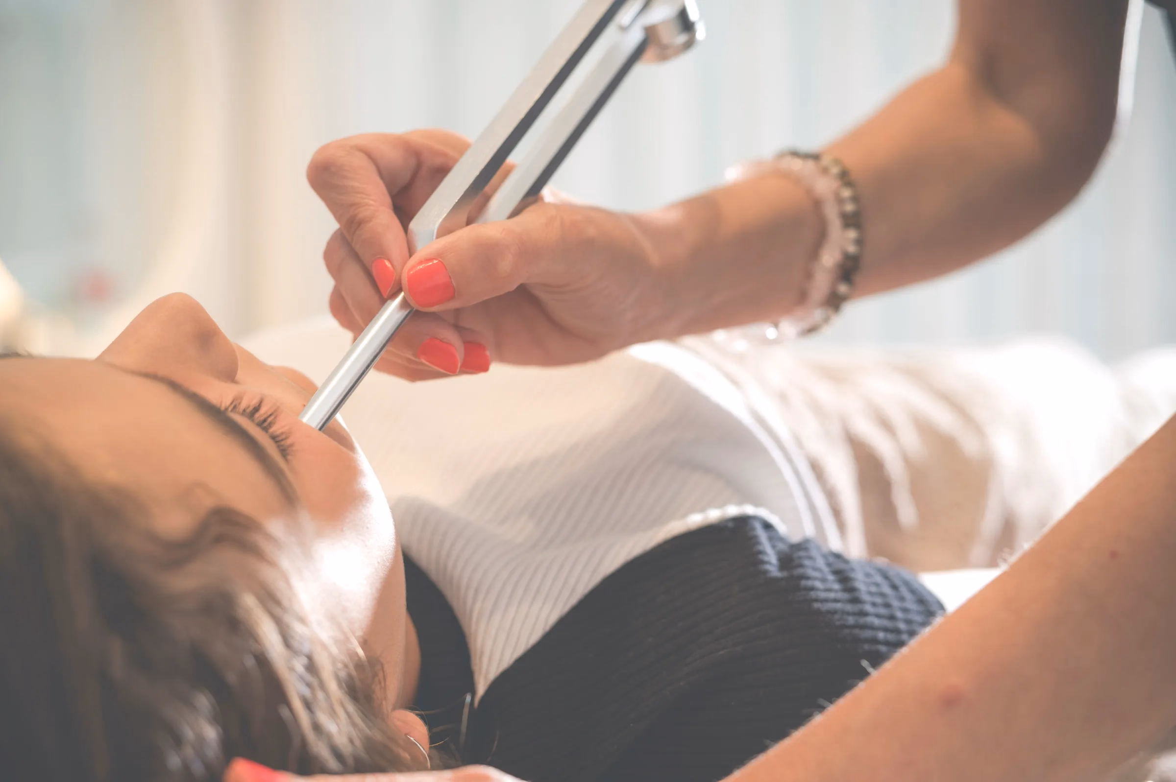 Detalle de una sesión de reflexología facial: el instrumento recorriendo la frente.
